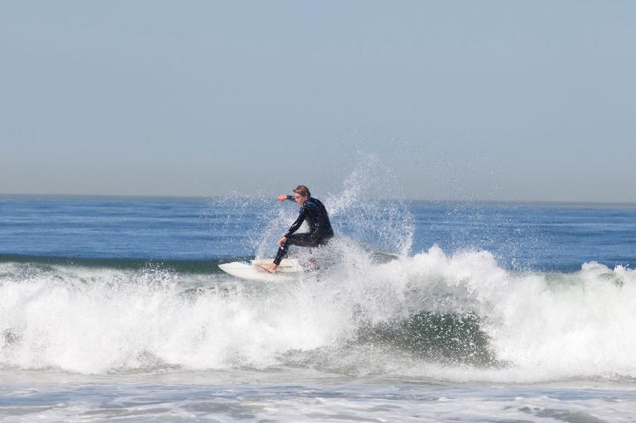 male student surfing at beach